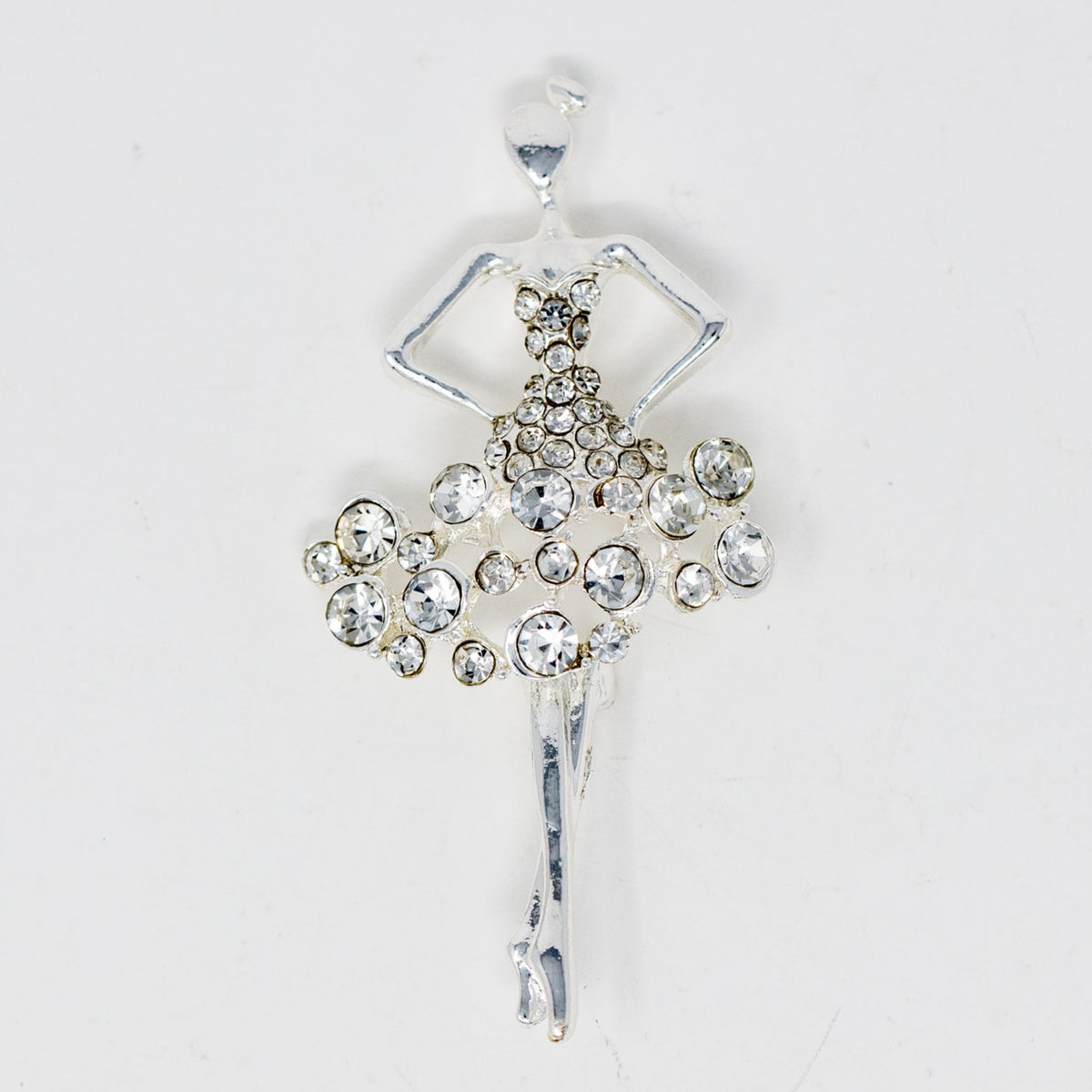 A collectible pin featuring a silver-colored ballerina figure adorned with rhinestones.